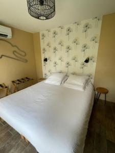 a bedroom with a white bed and a wall with umbrellas at Cabane du Circuit in Le Mans