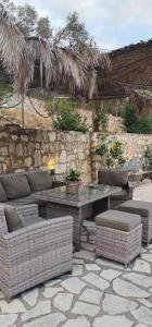 a patio with a table and chairs and a stone wall at Alegria studios in Gaios