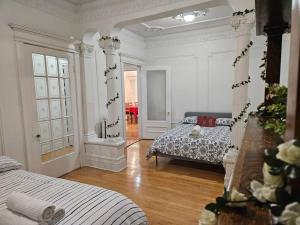 a white room with two beds and a mirror at Mona Bella Beautiful Home In Mile End in Montréal