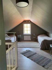 a attic bedroom with two beds and a window at Villa VitvikenA in Gotland Pool in Slite