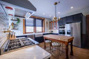 a kitchen with black cabinets and a wooden counter top at Squiers 1882 in Maquoketa
