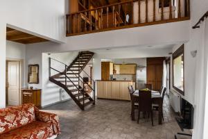 a living room with a table and a spiral staircase at Viros Holiday House in Virós