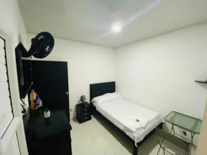 a small bedroom with a bed and a chair at Alojamientos Z.V in Tumaco