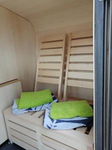 a bunk bed with two green pillows on it at "Das kleine Strandglück" in Grömitz