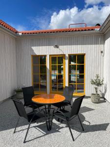 a patio with a table and chairs in front of a building at Villa VitvikenA in Gotland Pool in Slite