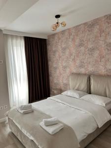 a bedroom with a large bed with two towels on it at Elegance in Bucharest