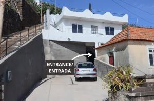 un'auto parcheggiata in un parcheggio di fronte a un edificio di Fifty's House 2 By Sam Houses a Ribeira Brava Altre 7 foto