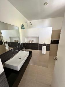 un bagno con un lavandino bianco e uno specchio di Vista Mare Spectacular Ocean View Top Floor 1-Bedroom Condo, Samana a Santa Bárbara de Samaná