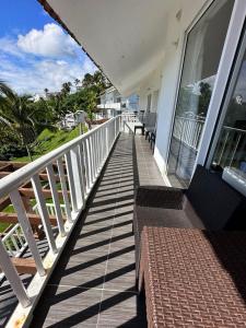 a porch of a house with a bench on it at Vista Mare Ocean View Top Floor Condo, Samana in Santa Bárbara de Samaná