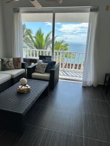 a living room with a couch and a view of the ocean at Vista Mare Ocean View Top Floor Condo, Samana in Santa Bárbara de Samaná
