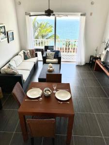 a living room with a couch and a table at Vista Mare Ocean View Top Floor Condo, Samana in Santa Bárbara de Samaná