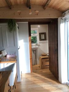 uma cozinha com uma porta de madeira e um lavatório em Aspen Leaves: The perfect farm retreat em Graffham