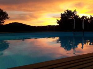 a sunset over a swimming pool at sunset at Cerezas y Miel in Majaelrayo