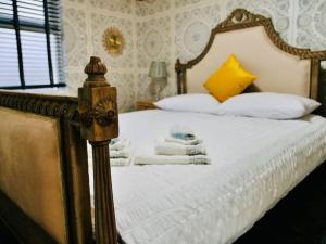 een slaapkamer met een bed met witte lakens en gele kussens bij Deluxe 4 Bed London House Nr Stratford in Londen