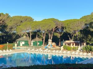 a swimming pool with white chairs and a playground at Domaine Valescure Appartement 1 ou 2 pieces vue jardin ou piscine in Saint-Raphaël