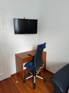a desk with a chair and a television on a wall at Zimmer in Jembke in Jembke