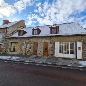 une ancienne maison en pierre sur le côté de la rue dans l'établissement Bel appartement « Les Monts du Cantal », à Murat