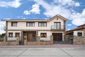 a large white house with a stone wall at Casa Las Torres in Navas de Oro