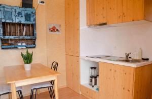 a small kitchen with a table and a sink at O Refugio Nas Vinhas in Badim