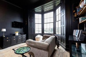 ein Wohnzimmer mit einem Sofa und einem großen Fenster in der Unterkunft Dickens' Nook in Hartlepool