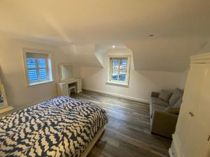 a bedroom with a bed and a couch and two windows at The Last Resort in Warrenpoint