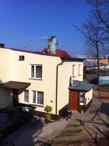 une maison blanche avec un toit rouge dans l'établissement Chess Apartament, à Augustów