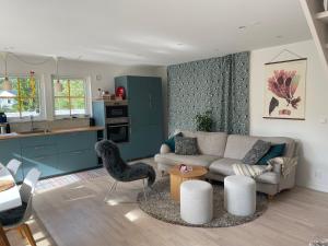 a living room with a couch and a table at Villa Vitviken Sleeps 4 with Pool in Slite