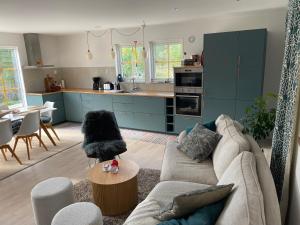 a living room with a couch and a kitchen at Villa Vitviken Sleeps 4 with Pool in Slite