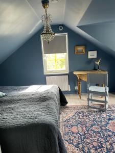 een slaapkamer met een bed, een tafel en een raam bij Villa VitvikenB i Gotland Pool in Slite