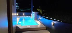 a swimming pool with lights on a balcony at night at Staycation @ Sandari Batulao in Tagaytay