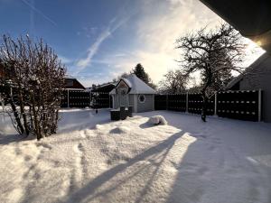 een tuin bedekt met sneeuw met een hek bij Haus der Möglichkeiten in Bad Lauterberg