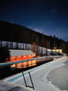 斯托尼拉斯奇的住宿－Chata Ignasia pod Śnieżnikiem 1 na działce，游泳池在晚上的雪中