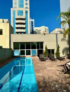une piscine en face d'un bâtiment dans l'établissement Studio Premium Bela Cintra, à São Paulo