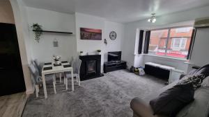 a living room with a table and a fireplace at Seaside 2 bed flat sleeps 6 in Lee-on-the-Solent