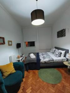 Studio Calm In Fabrica في بورتو: غرفة معيشة مع سرير وأريكة