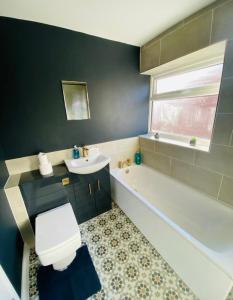 a bathroom with a white toilet and a sink and a tub at The Beautiful Bungalow Amazing location for Chester & Zoo in Wervin