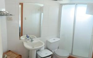 Baño blanco con aseo y lavamanos en Hostal Quiriyuca Sur, en Horcón
