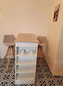 a table and two stools in a room at Apartmán na Náměstí. in Český Brod