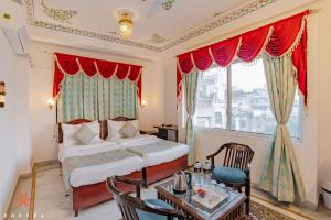 a bedroom with a bed and a table and a window at Zostel Udaipur in Udaipur
