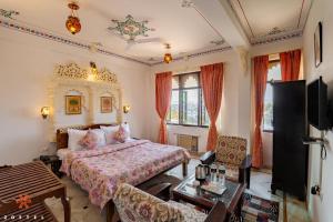 Zostel Udaipur في أودايبور: غرفة نوم بسرير وتلفزيون في غرفة