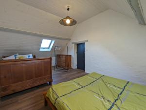 ein Schlafzimmer mit einem Bett und einer Kommode darin in der Unterkunft La maison de Joe in Beaumont