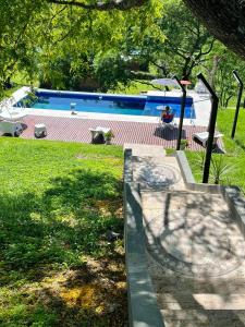 a swimming pool in a yard with a person sitting in a chair at Casa Quincho ROMA in Salta