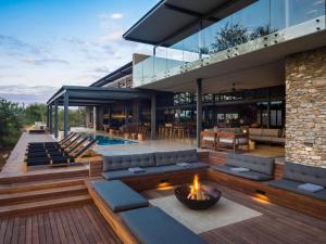 a house with a fire pit and a pool at Kruger Lodge Mjejane in Hectorspruit