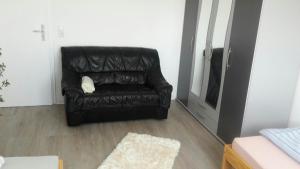 uma cadeira de couro preta sentada numa sala de estar em Otthonos Szállás em Stuttgart