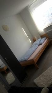 uma pequena cama num quarto com uma janela em Otthonos Szállás em Stuttgart