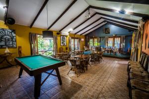 a pool table in a room with tables and chairs at Hotel Manavai in Hanga Roa
