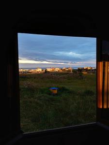 a view from a window of a field with a table at Casa de madera en playa de Cabo Polonio con dos ambientes para 5 huespedes in Cabo Polonio +21 photos