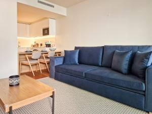 sala de estar con sofá azul y mesa en Bayline Condominium - Heated indoor Swimming pool - SPA - By Bedzy, en Armação de Pêra