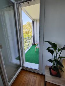 una puerta corredera de cristal que da a un balcón con una planta en Jolie chambre avec vue dans appartement en colocation, en Grenoble