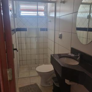 パリョサにあるPousada paraíso Ap próximo ao centro da praia de baixoのトイレ、洗面台、鏡のあるバスルーム